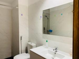 ein Badezimmer mit Waschbecken, Toilette und Spiegel in der Unterkunft Le cocon bleu in Aourir
