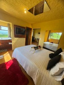 a bedroom with a large white bed in a room at Mirante do Sol 1 - café da manhã, hidro e lareira in Córrego do Bom Jesus +44 photos