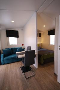 a bedroom with a bed and a desk and a couch at Mobilheim Summer Lounge Appartment II in Borgdorf-Seedorf