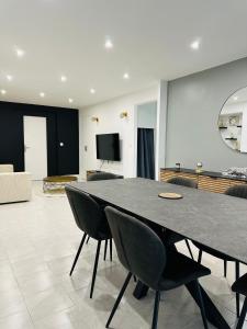 a dining room with a black table and chairs at Villa avec Spa & Sauna, Évasion in Béziers