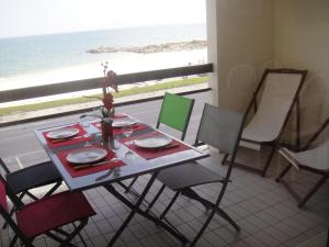 a table and chairs with a view of the ocean at Residence Front De Mer in Quiberon