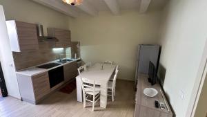 a small kitchen with a table and a refrigerator at Parva Domus Piazzetta Maratea in Maratea