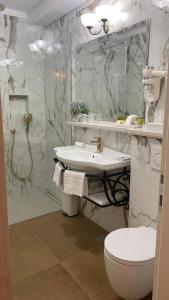a bathroom with a sink and a toilet and a shower at Opera Heritage Rooms in Split