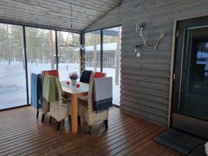 a porch with a table and chairs on it at Harjunranta in Kuusamo