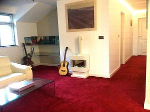 a living room with a guitar and a fireplace at Lanteague Cornwall with stunning Sea Views in Gillan