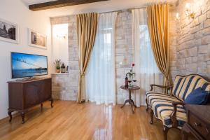 a living room with a couch and a television at Opera Heritage Rooms in Split