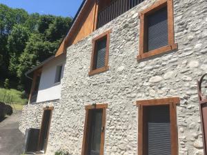 a stone building with wooden shutters on it at Gîtes chez Sylvie in Arreau +6 photos