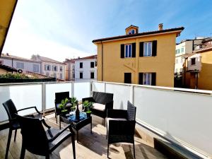 a patio with chairs and a table on a balcony at HomeHolidaySanremo - Luxe & Glamour in Sanremo