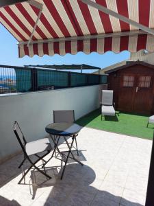 a table and chairs on a balcony with an umbrella at Casa BLAVA in Benicarló
