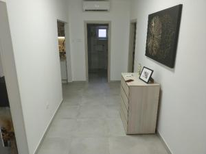 a hallway with white walls and a table with a picture on it at Dome&Mare in Slatine