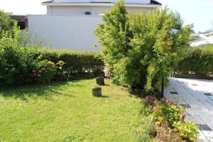 un jardín con árboles y flores en un patio en Casa Ostrea, en Kamperland