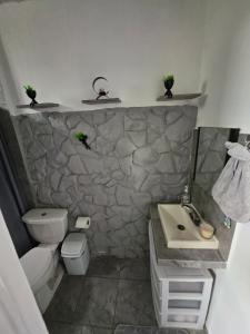 ein Badezimmer mit einem Waschbecken und einer Steinmauer in der Unterkunft Casa Comfortable and Complete, maximum 8 people in Tierra Colorada