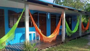 a house with hammocks hanging on the porch at Pousada e Camping Rhaiana in Ilha do Mel