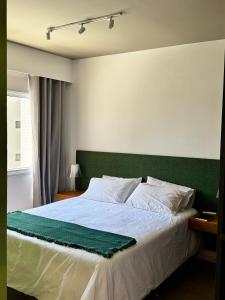 a bedroom with a large bed with a green headboard at Luxuoso e Aconchegante Ed Jh Palhano 1108 in Londrina +27 photos