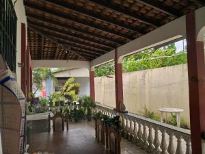 un portico con sedie, tavolo e recinzione di Casa de praia a Belém