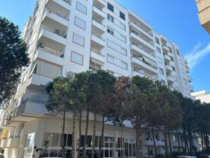 a white apartment building with trees in front of it at Fabio Apartment Qerret in Golem