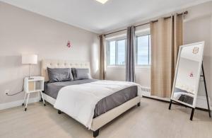 une chambre blanche avec un lit et une fenêtre dans l'établissement Chic Downtown Montreal Condo 2 Bed 2 Bath Free Indoor Parking, à Montréal