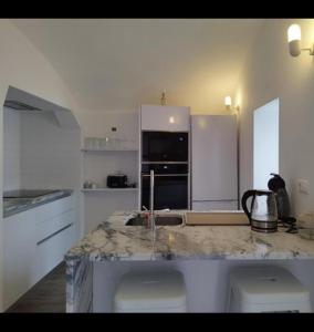 a kitchen with a marble counter top with a sink at Casinha do Pão Bolorento in Évora