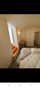 a bedroom with a bed and a desk and a window at Casinha do Pão Bolorento in Évora +2 photos
