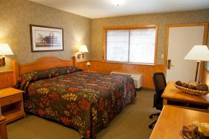 a hotel room with a bed and a desk at Poulsbo Inn & Suites in Poulsbo