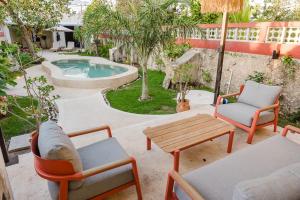 a patio with chairs and a table and a pool at La Casa Mosaica in Campeche