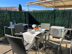 un patio avec une table, des chaises et un radiateur dans l'établissement Maisonnette - Résidence Malamousque, à Aigues-Mortes