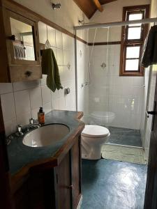 a bathroom with a sink and a toilet at Chalé Coimbra in São Bento do Sapucaí