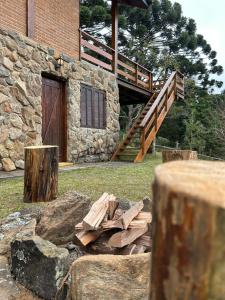 a pile of wood in front of a building at Chalé Coimbra in São Bento do Sapucaí +27 photos