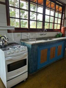 a kitchen with a stove and a sink at Chalé Coimbra in São Bento do Sapucaí