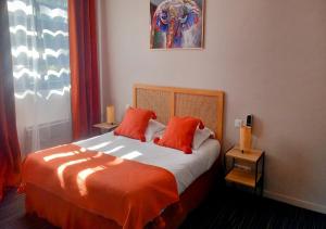 a bedroom with a bed with two orange pillows at Les Jardins de L'Ocean - Climatisé in Biscarrosse-Plage