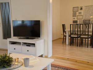 a living room with a television on a white cabinet at Ostsee-Ferienhaus-Richter in Ribnitz-Damgarten