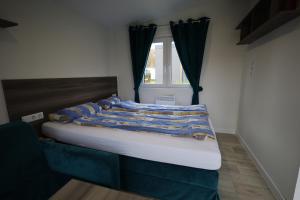 a bed in a room with a window at Mobilheim Sol in Borgdorf-Seedorf