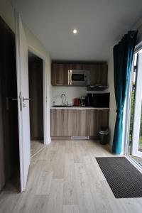a kitchen with wooden floors and a counter top at Mobilheim Sol in Borgdorf-Seedorf