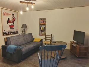 a living room with a couch and a television at Chez Céline & Ludo in Villabon