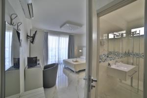 Un baño con una cama, un lavabo y un espejo. en Riviera Luxury Rooms, en Porto Cesareo 140 fotos más