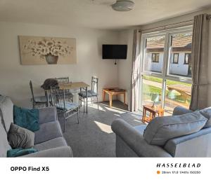 a living room with a couch and a table and chairs at Tolroy manor holiday cottage in Saint Erth
