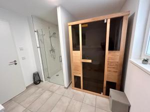 une salle de bain avec douche et porte vitrée dans l'établissement Ferienhaus Michel, à Butjadingen