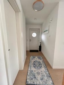 un couloir avec un tapis et une porte avec une fenêtre dans l'établissement Ferienhaus Michel, à Butjadingen 6 autres photos