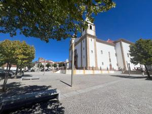 un grand bâtiment blanc avec une tour d'horloge dans une rue dans l'établissement Casa Rural Alegría, à San Pedro