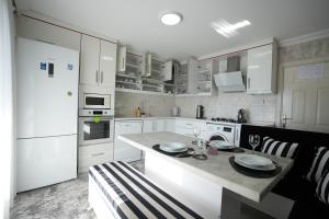 a kitchen with white cabinets and a table with plates on it at Çilek Home in Pamukkale
