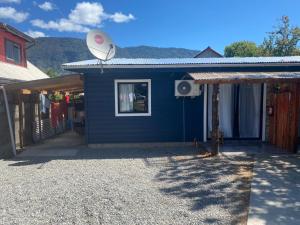 a blue house with a satellite on top of it at Mini departamento 2 in Coñaripe