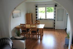 a dining room with a table and chairs and a window at Dat lütte Ferienhuus an`t Dannewark in Dannewerk