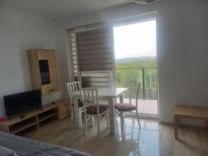 une salle à manger avec une table, des chaises et une télévision dans l'établissement Tauzen Apartaments 24, à Katowice