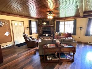 a living room with a couch and a fireplace at The Game Cabin at Rustic River in Austinburg