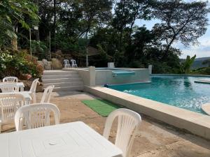 a table and chairs next to a swimming pool at Casa Quinta Confort-privado in Melgar