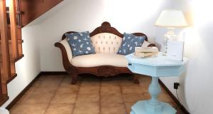 a room with a chair and a table with a lamp at casa a schiera, a 150mt dal mare in Lido di Jesolo