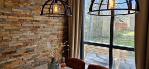 two lights hanging over a table in front of a window at Gezellig 6pers Familiehuis grote tuin met BBQ aan meer Gelderland in Ewijk +89 photos