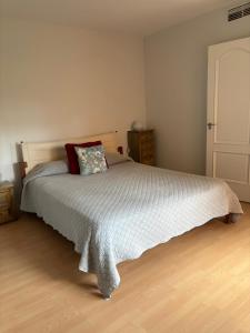 Un dormitorio con una cama con un edredón blanco. en Charming 3 Bedroom apartment with sea view in the heart of Sotogrande, en Sotogrande