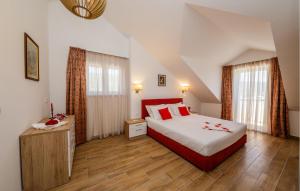a bedroom with a large bed and two windows at Amazing Home In Kastel Stafilic in Kastel Stafilic