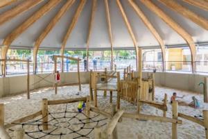 a playground in a gazebo with wooden play equipment at Vintage Forest Chalet in IJhorst